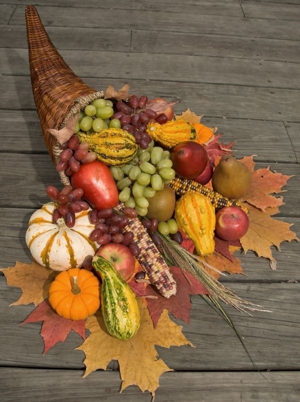 A bountiful display of fresh fruits and veggies sprawled on a rustic wooden floor, celebrating the abundant harvest.