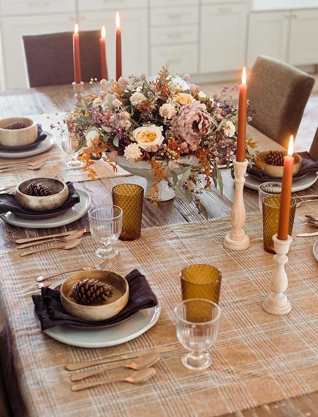 An exquisite table arrangement featuring flickering candles and vibrant flowers, creating a charming and rustic ambience.