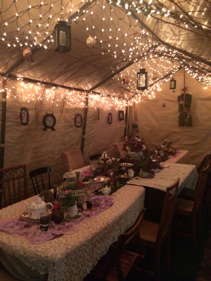 Experience the warm ambiance of a friendsgiving celebration, surrounded by lantern-lit tents and a charming table set with chairs, all aglow with string lights.